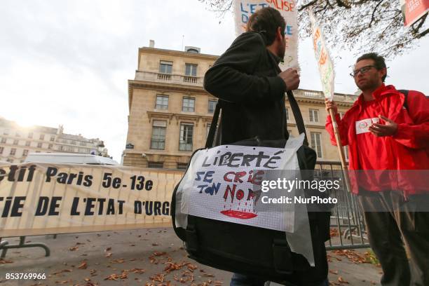 Man holds a bag reading 'Freedom, I shout your name' during a protest against 'permanent state of emergency' in Paris on September 25 in front of the...