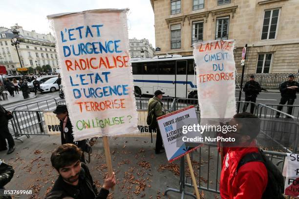 Man holds a sign reading 'permanent state of emergency makes radical, permanent state of emergency terrorizes ' during a protest against 'permanent...