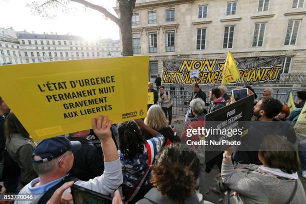 Man holds a sign reading 'permanent state of emergency hurts freedom' during a protest against 'permanent state of emergency' in Paris on September...