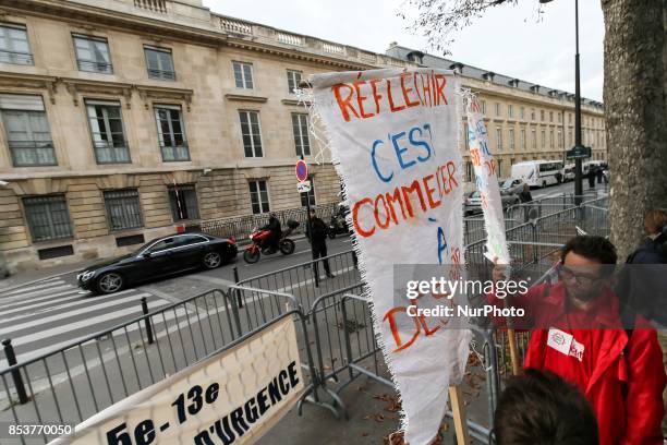 Man holds a sign reading 'permanent state of emergency makes radical, permanent state of emergency terrorizes ' during a protest against 'permanent...