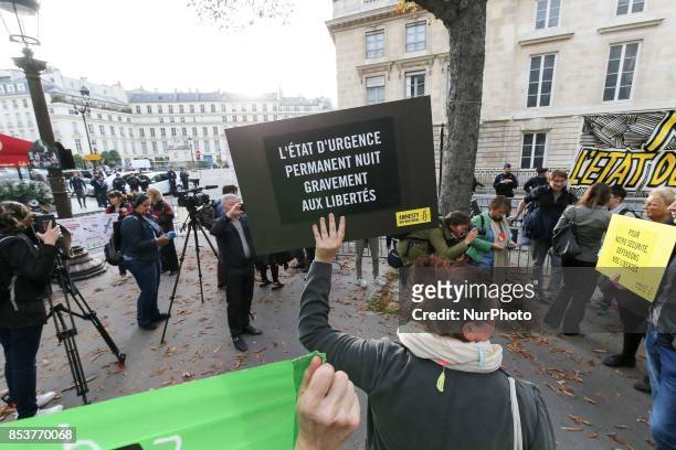 Woman holds a bag reading 'Human rights protect us, let us protect them' during a protest against 'permanent state of emergency' in Paris on...