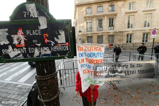 Man holds a sign reading 'permanent state of emergency makes radical, permanent state of emergency terrorizes ' during a protest against 'permanent...