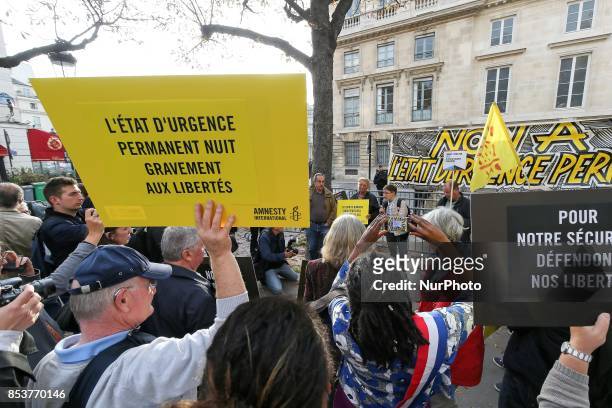 Man holds a sign reading 'permanent state of emergency hurts freedom' during a protest against 'permanent state of emergency' in Paris on September...