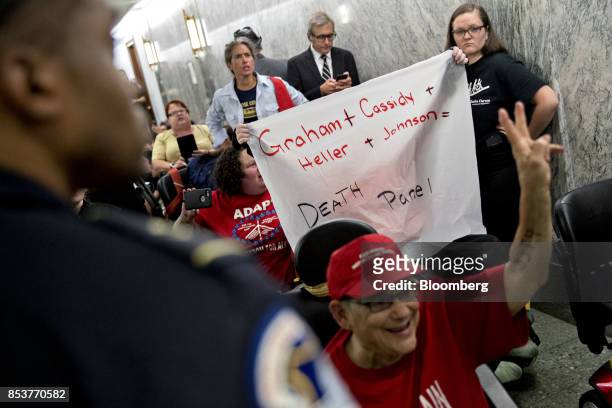 Demonstrators hold a sign opposed to the Graham-Cassidy-Heller-Johnson proposal outside a Senate Finance Committee hearing in Washington, D.C., U.S.,...