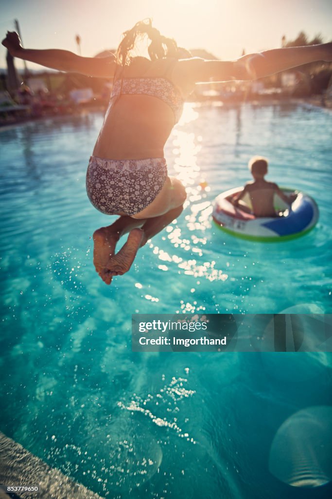 Irmão e irmã jogando na piscina resort