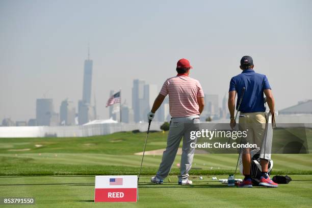 Patrick Reed of the U.S. Team and his caddie Kessler Karain on the range prior to the start of the Presidents Cup at Liberty National Golf Club on...