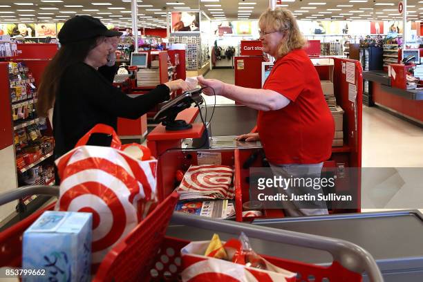 Target worker Ellen Gibran-Hesse helps a customer at a Target store on September 25, 2017 in San Rafael, California. Target Corp. Annouced plans to...
