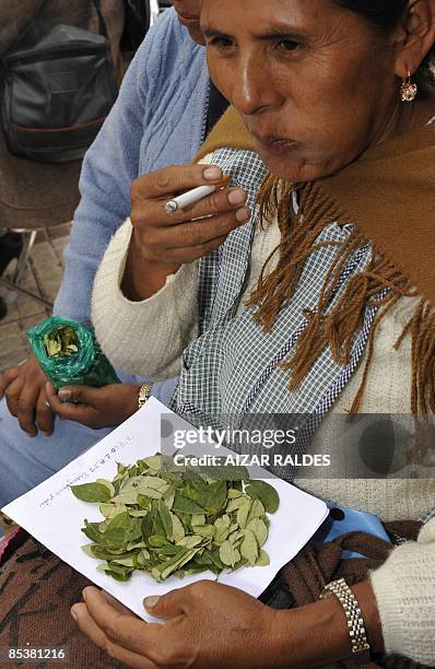 An indigenous woman of the Aymara ethnic group chews coca leaves and smokes during a rally in La Paz March 11, 2009. Several organizations of...