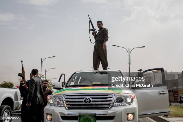 Soldier fires his gun in the air to celebrate the referendum on the road outside a voting station on September 25, 2017 in Kirkuk, Iraq. Despite...