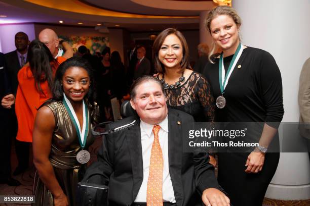Simone Biles, Marc Buoniconti, Cynthia Halelamien, and Kim Clijsters attend the 32nd Annual Great Sports Legends Dinner To Benefit The Miami...