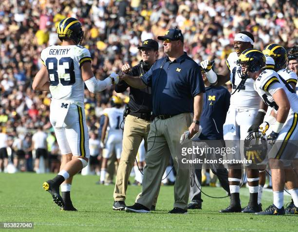 Michigan tight end Zach Gentry is congratulated by tight ends coach Greg Frey, right, and head coach Jim Harbaugh after he caught a second quarter...