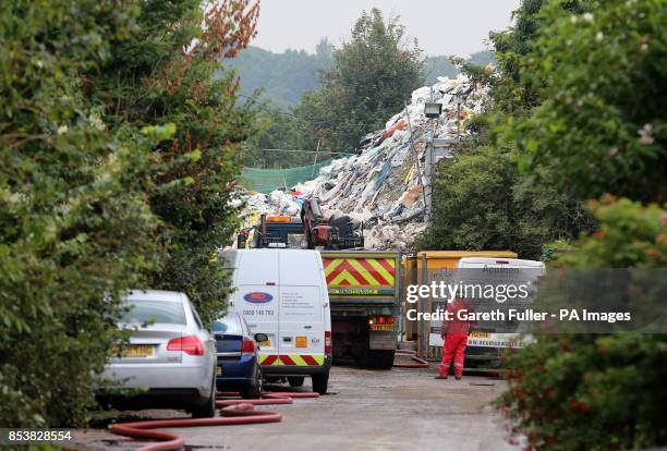 Waste clearance experts work to clear a mountain of rubbish in Cornwall Drive in St Paul's Cray, Orpington, Kent which has been at the bottom of the...