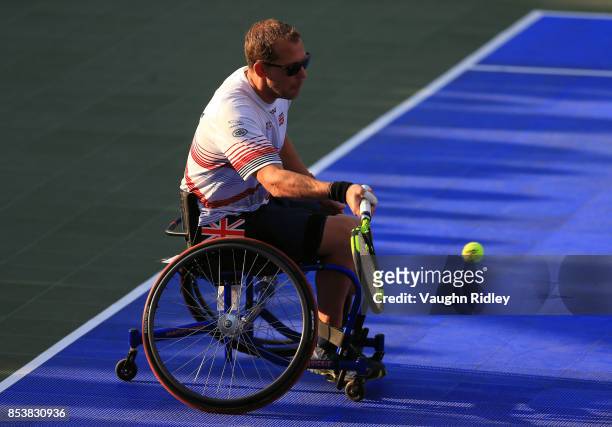 Kevin Drake of the United Kingdom plays a shot in the Wheelchair Tennis Gold medal match against Glenn Barnes and Aaron Gibbs of New Zealand during...