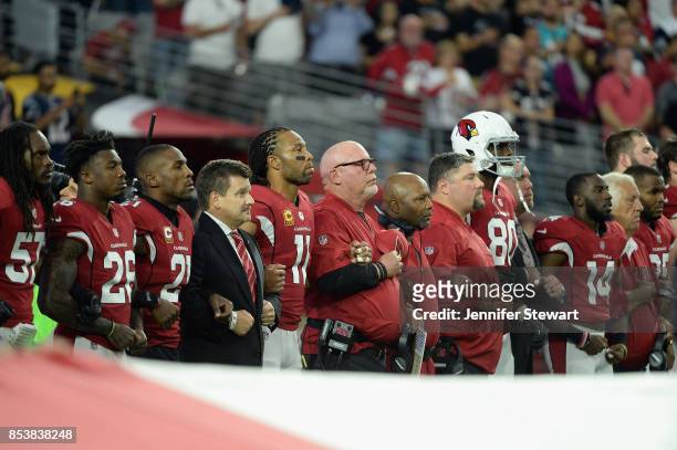 Wide receiver Larry Fitzgerald and head coach Bruce Arians of the Arizona Cardinals link arms during the National Anthem before the start of the NFL...