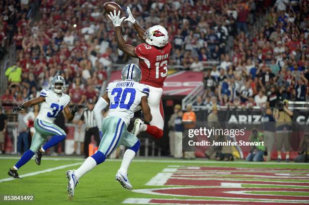 Wide receiver Jaron Brown of the Arizona Cardinals catches a touchdown over cornerback Anthony Brown of the Dallas Cowboys during the first quarter...