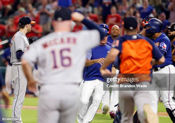 Both benches clear to separate starting pitcher Collin McHugh of the Houston Astros, left, and Carlos Gomez of the Texas Rangers, right, during the...