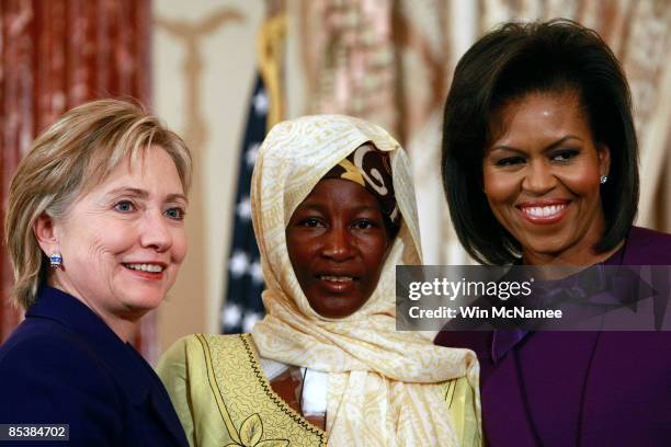 First lady Michelle Obama and U.S. Secretary of State Hillary Clinton greet Hadizatou Mani of Niger at an awards ceremony to announce this year's...