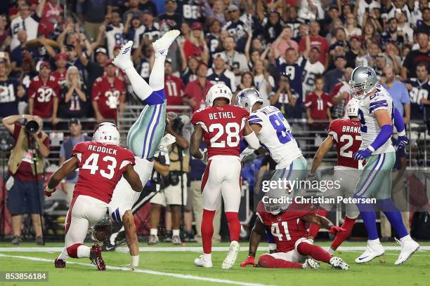 Quarterback Dak Prescott of the Dallas Cowboys dives into the end zone to score on a ten yard rushing touchdown against the Arizona Cardinals during...