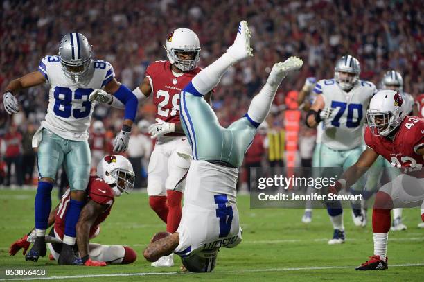Quarterback Dak Prescott of the Dallas Cowboys dives into the endzone to score on a ten yard rushing touchdown against the Arizona Cardinals during...