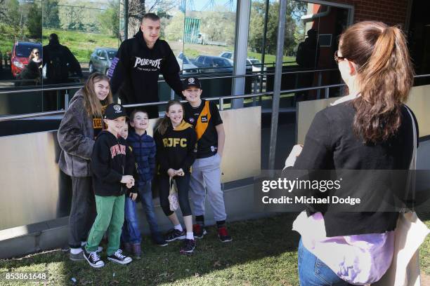 Dustin Martin, a winner of the Brownlow medal last night, poses with young Tigers fans ahead of the Richmond Tigers AFL training session at Punt Road...