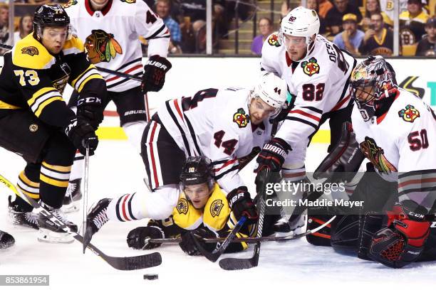 Charlie McAvoy of the Boston Bruins and Anders Bjork look for a shot on goal against Corey Crawford of the Chicago Blackhawks during the third period...