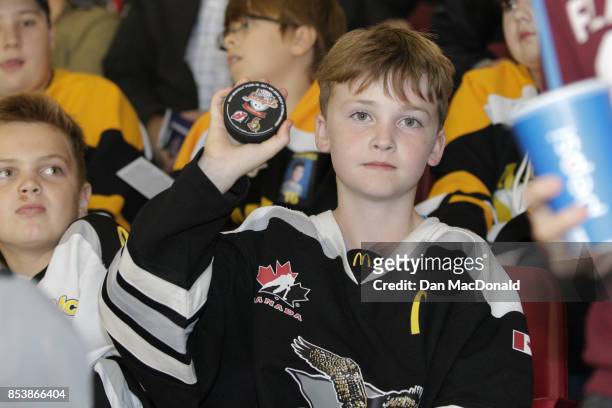 Young fan holds up a game puck for the 2017 Kraft Hockeyville Canada game between the New Jersey Devils and Ottawa Senators at Credit Union Place on...