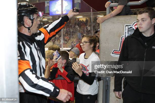 Referee Tim Peele passes a game puck to a young fan after the end of the first period. 2017 Kraft Hockeyville Canada game between the New Jersey...