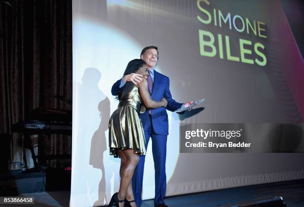Honoree Simone Biles and Bob Costas speak onstage during the 32nd Annual Great Sports Legends Dinner To Benefit The Miami Project/Buoniconti Fund To...