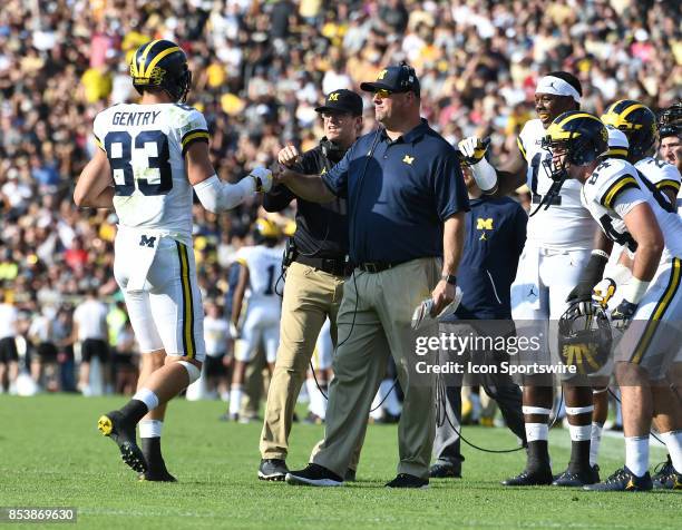 Michigan tight end Zach Gentry is congratulated by tight ends coach Greg Frey, right, and head coach Jim Harbaugh after he caught a second quarter...