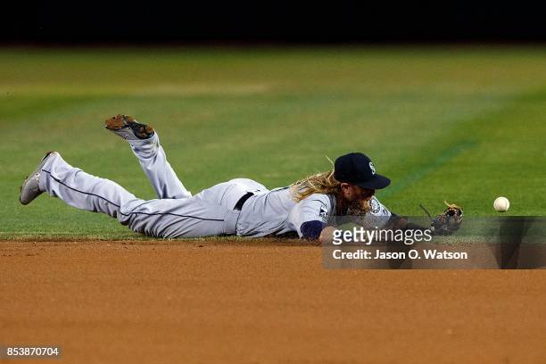 Taylor Motter of the Seattle Mariners dives for but is unable to field a ground ball hit off the bat of Matt Joyce of the Oakland Athletics during...