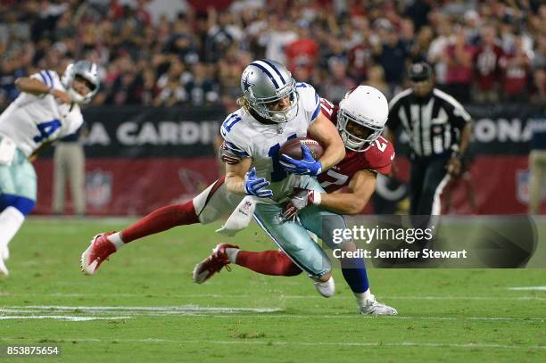 Wide receiver Cole Beasley of the Dallas Cowboys is hit by strong safety Tyvon Branch of the Arizona Cardinals during the second half of the NFL game...