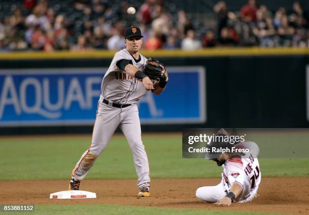 Second baseman Joe Panik of the San Francisco Giants throws to first base over Rey Fuentes of the Arizona Diamondbacks to complete a double play...