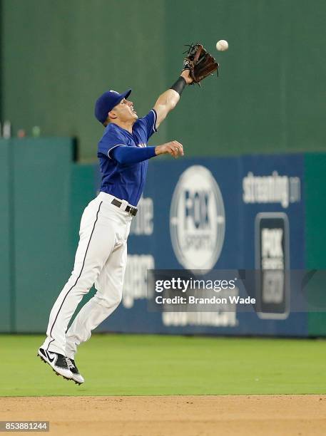 Second baseman Drew Robinson of the Texas Rangers is unable to catch a hit by Marwin Gonzalez of the Houston Astros during the eighth inning of a...