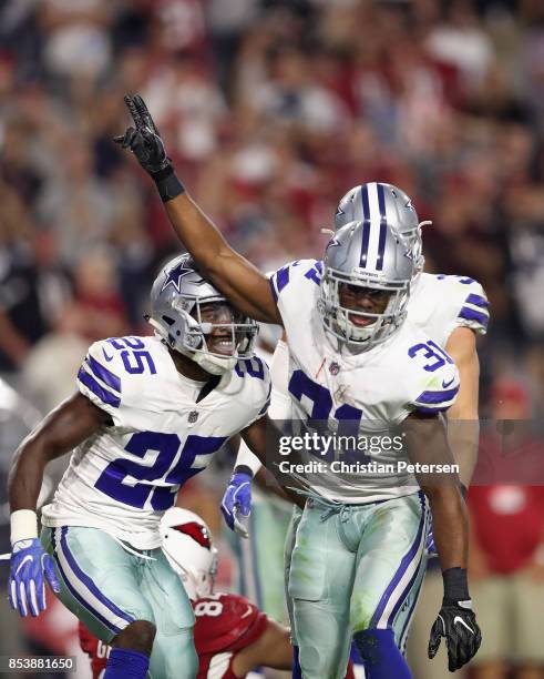 Free safety Byron Jones of the Dallas Cowboys reacts with safety Xavier Woods of the Dallas Cowboys after breaking up a fourth down pass during the...