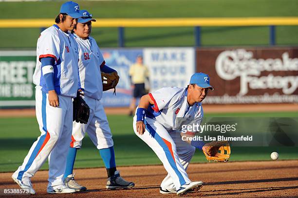 Dae Ho Lee, Tae Kyun Kim and Bum Ho Lee of Korea warm up before an exhibition game against the San Diego Padres at Peoria Stadium March 11, 2009 in...