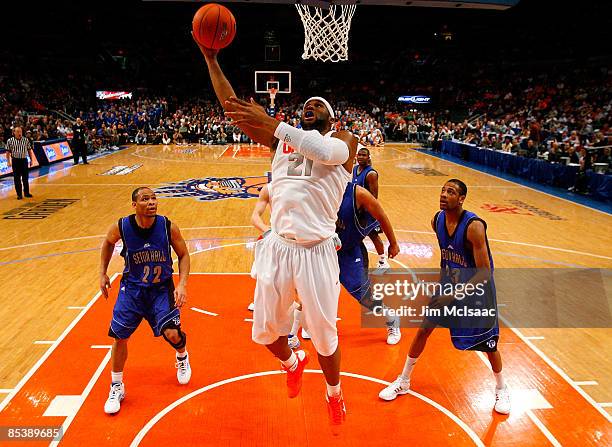 Arinze Onuaku of the Syracuse Orange drives to the hoop against Paul Gause and Robert Mitchell of the Seton Hall Pirates during the second round of...