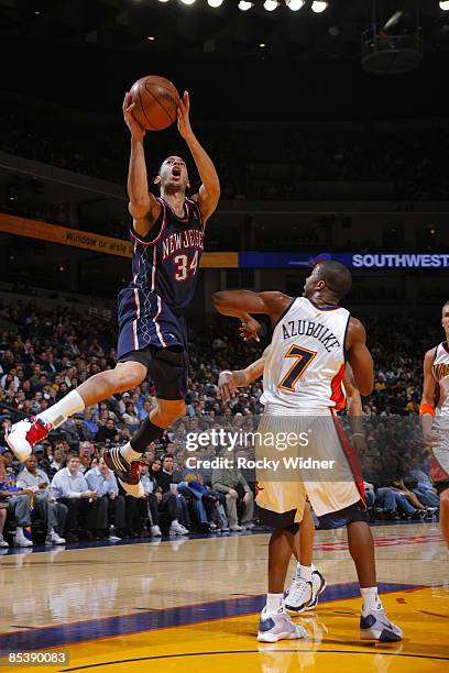 Devin Harris of the New Jersey Nets goes up for a shot over Kelenna Azubuike of the Golden State Warriors on March 11, 2009 at Oracle Arena in...