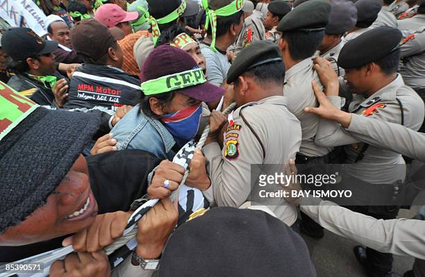 Victims of the mud volcano on bungled gas drilling by oil and gas firm Lapindo Brantas, clash with police during a rally in front of the presidential...