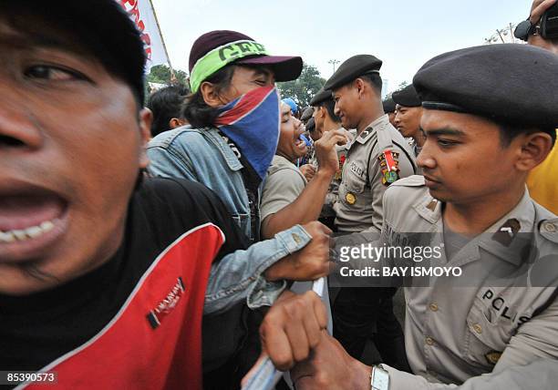 Victims of the mud volcano on bungled gas drilling by oil and gas firm Lapindo Brantas, clash with police during a rally in front of the presidential...