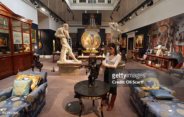Gallery assistant at Sotheby's auction house examines a statue included in the forthcoming sale of furniture and works of art owned by Gianni...