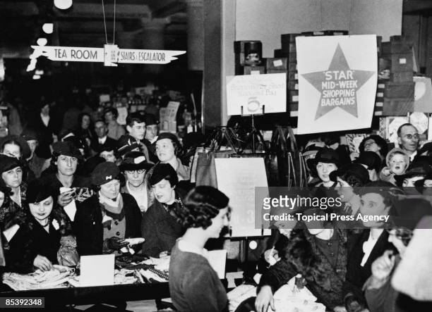 Shoppers crowd round a counter at Selfridges department store on Oxford Street, London, 7th December 1939.