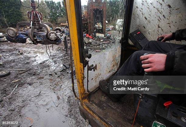 Scrap car is dragged by a mechanical dragger as it is processed in a car dismantlers and scrapyard on March 12 2009 in Radstock, England. Government...