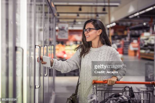 woman buying groceries in the market - frozen food stock pictures, royalty-free photos & images