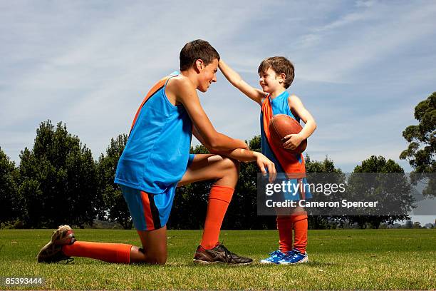 young boy facing older boy - australian rules football fotografías e imágenes de stock