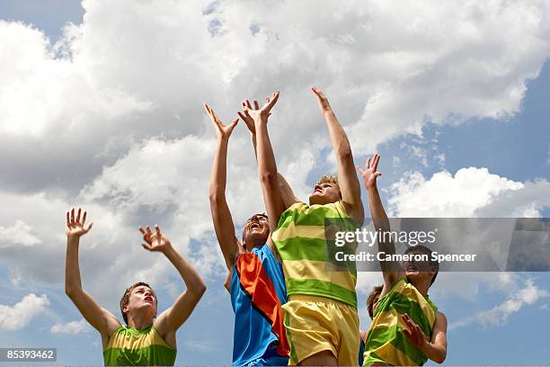 players leaping to catch football - jumping australia stock-fotos und bilder