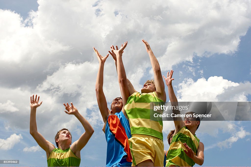 Players leaping to catch football