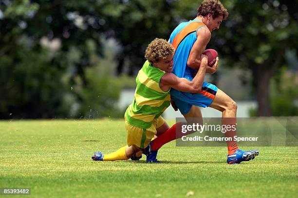player tackles his opposition in football game - placcare foto e immagini stock