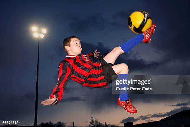 boy kicking football - child kicking stock pictures, royalty-free photos & images