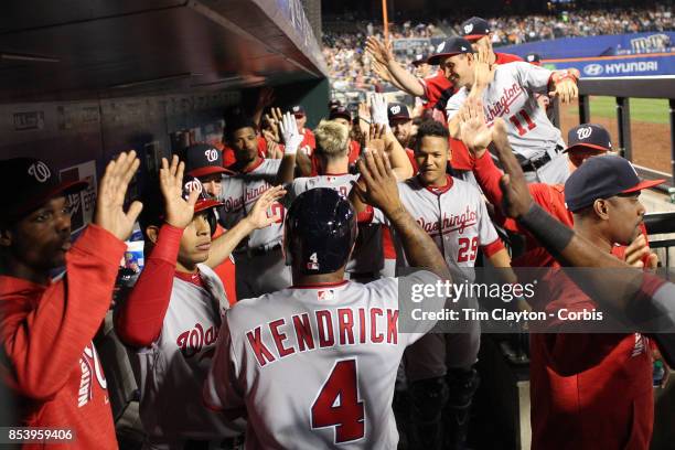 Adam Lind of the Washington Nationals is congratulated by team mates as he returns to the dugout after hitting a three run home run in the third...