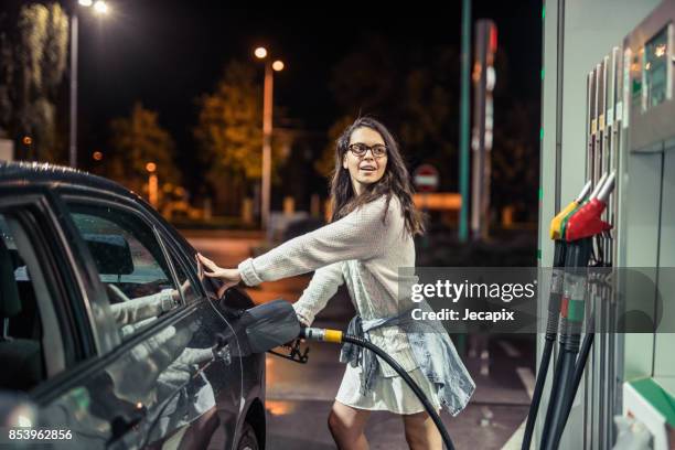 woman at the gas station - gas station at night stock pictures, royalty-free photos & images
